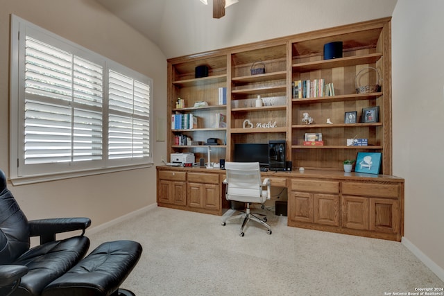 home office featuring lofted ceiling, built in desk, light colored carpet, and ceiling fan