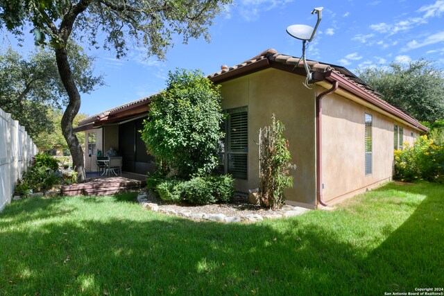 view of property exterior featuring a deck and a lawn