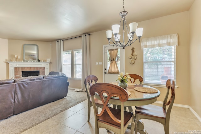 dining space featuring light tile patterned floors, a fireplace, a chandelier, and a healthy amount of sunlight