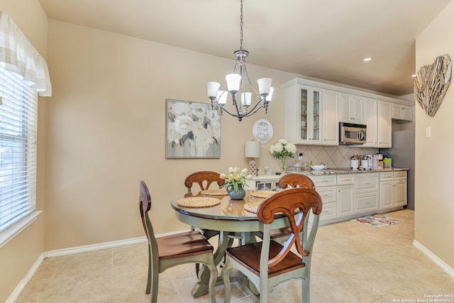 dining space with a notable chandelier and light tile patterned floors