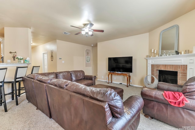 living room featuring light carpet, ceiling fan, and a brick fireplace