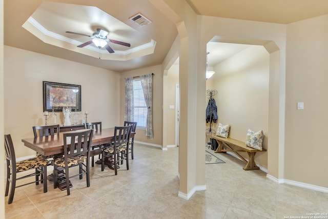 dining space featuring a tray ceiling, ceiling fan, and crown molding