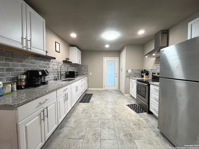 kitchen with wall chimney exhaust hood, stainless steel appliances, white cabinetry, and sink