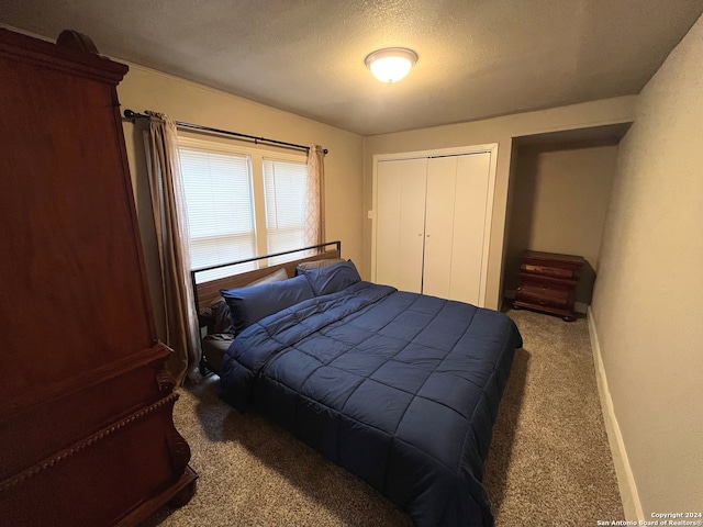 carpeted bedroom with a closet and a textured ceiling