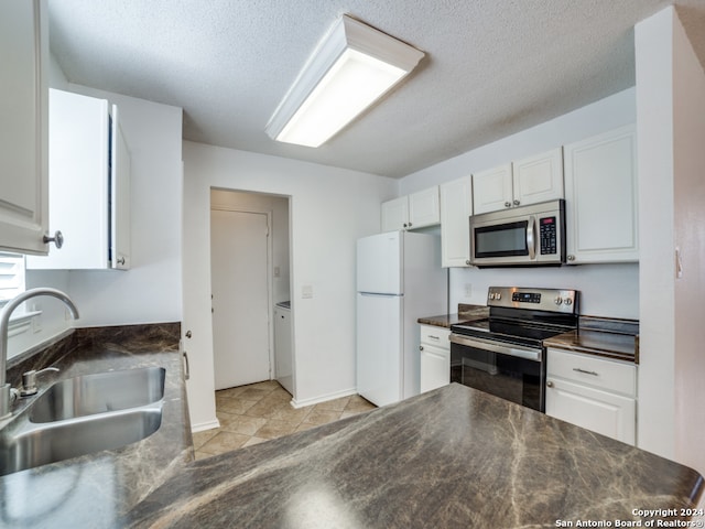 kitchen with white cabinetry, sink, a textured ceiling, light tile patterned floors, and appliances with stainless steel finishes