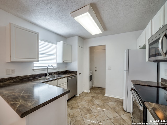 kitchen with white cabinets, sink, appliances with stainless steel finishes, and a textured ceiling