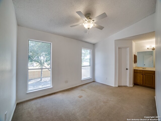 interior space featuring ceiling fan, a textured ceiling, and vaulted ceiling