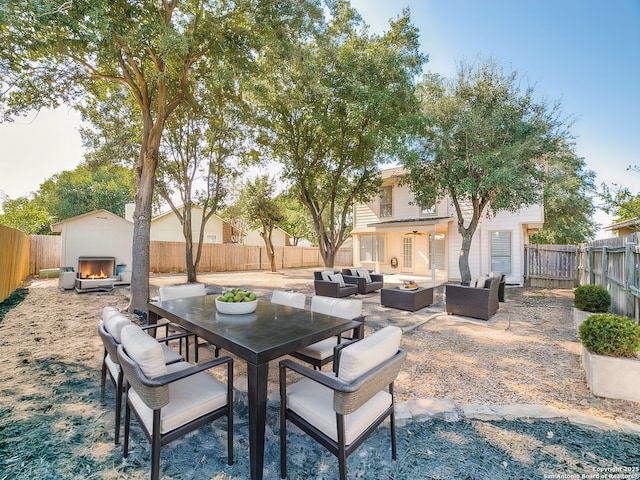 view of patio with an outdoor living space with a fireplace