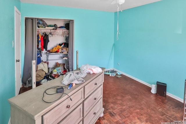 bedroom featuring dark parquet flooring and a closet