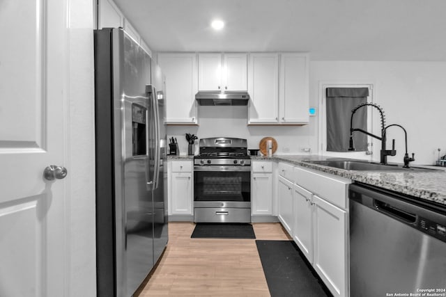 kitchen with light hardwood / wood-style flooring, white cabinets, appliances with stainless steel finishes, and sink