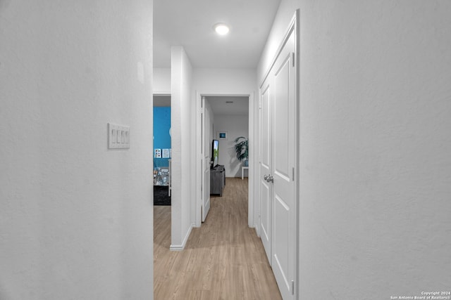 corridor with light hardwood / wood-style floors