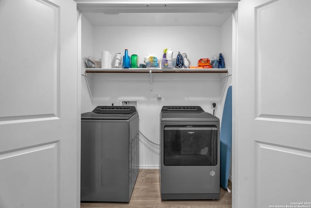 laundry room featuring light wood-type flooring and washer and clothes dryer