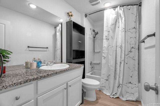 full bathroom with hardwood / wood-style floors, vanity, toilet, and shower / bath combo