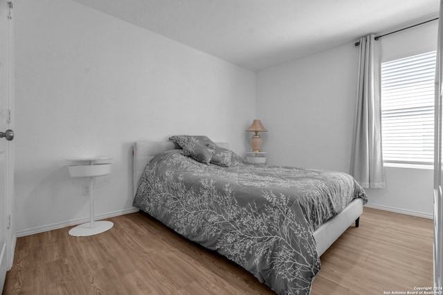 bedroom featuring hardwood / wood-style floors and multiple windows