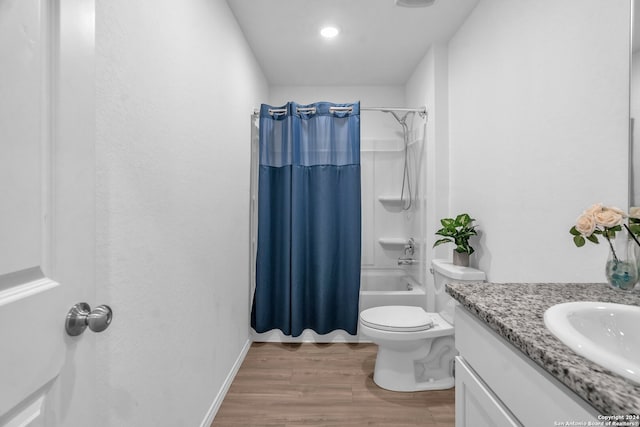 full bathroom featuring wood-type flooring, vanity, shower / bath combo with shower curtain, and toilet