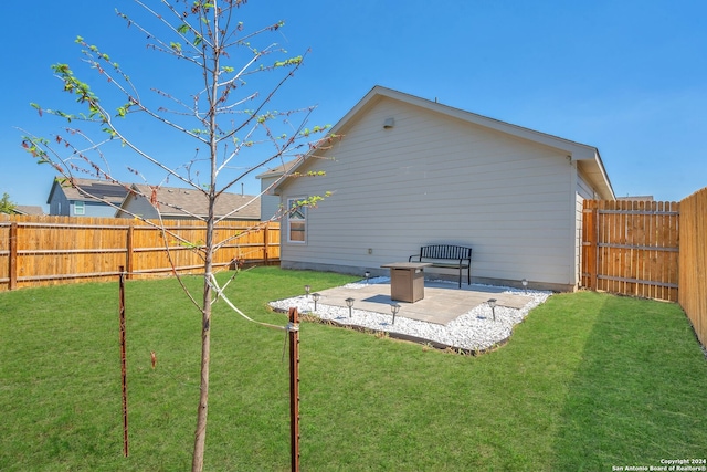 back of house featuring a lawn and a patio