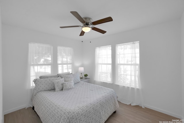 bedroom with ceiling fan and light hardwood / wood-style flooring