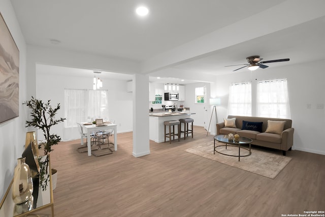 living room with ceiling fan and light hardwood / wood-style flooring