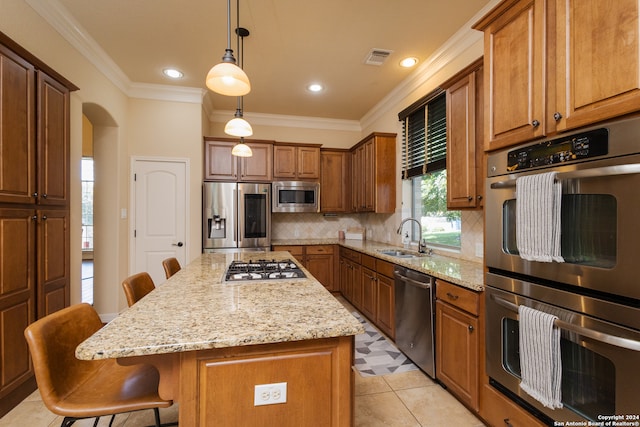 kitchen featuring hanging light fixtures, a breakfast bar, light stone countertops, stainless steel appliances, and a center island