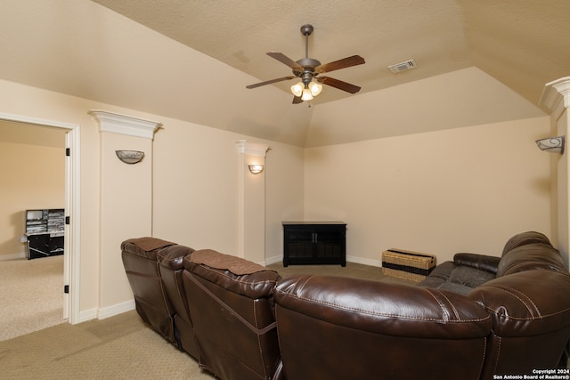 cinema room featuring lofted ceiling, ceiling fan, light colored carpet, and a textured ceiling