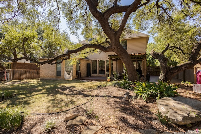 back of house featuring a pergola, a patio, and a yard