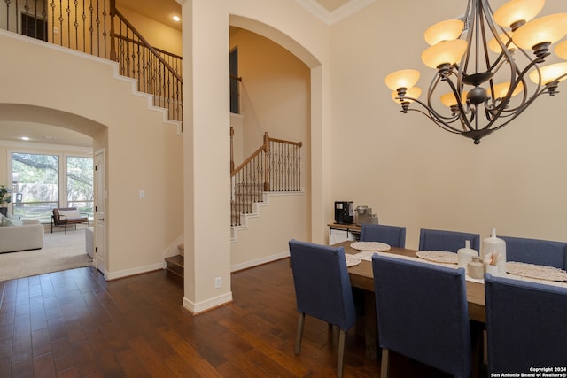 dining room featuring a towering ceiling, dark hardwood / wood-style floors, and crown molding