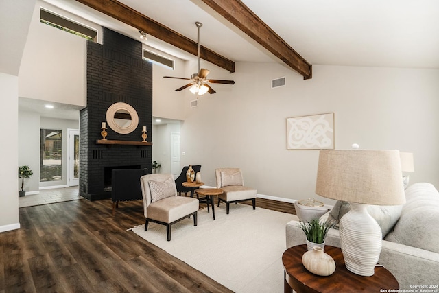 living room featuring dark wood-type flooring, high vaulted ceiling, a brick fireplace, ceiling fan, and beamed ceiling