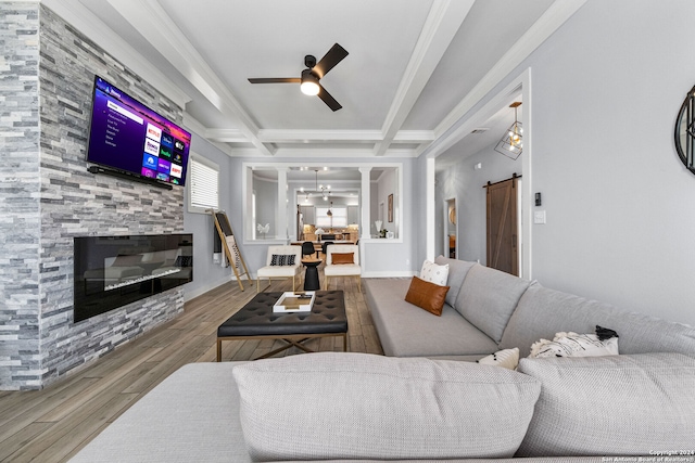 living room with ceiling fan, beam ceiling, hardwood / wood-style flooring, a fireplace, and a barn door