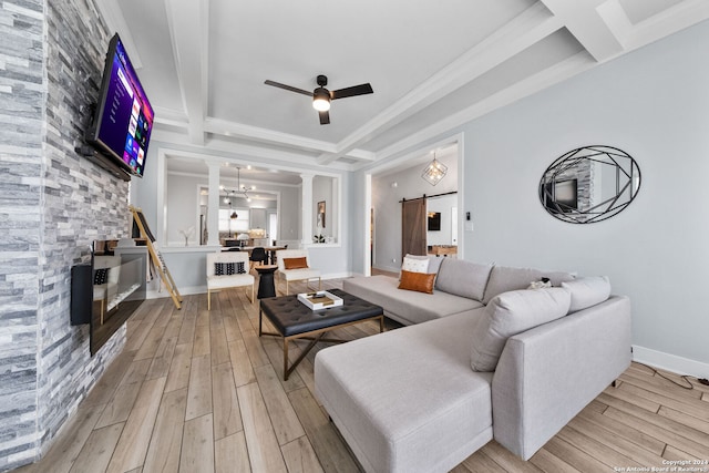 living room with light wood-type flooring, beam ceiling, decorative columns, a barn door, and ceiling fan