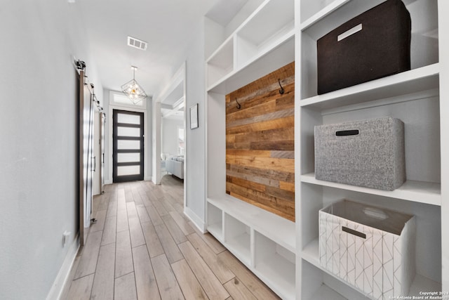 mudroom featuring a barn door and light hardwood / wood-style floors