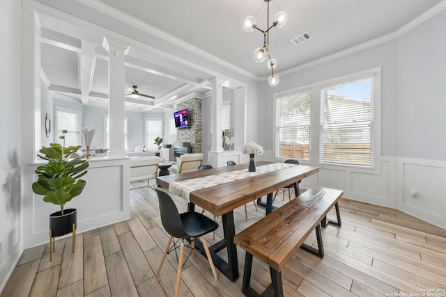 dining space featuring ceiling fan, light hardwood / wood-style floors, a fireplace, and crown molding