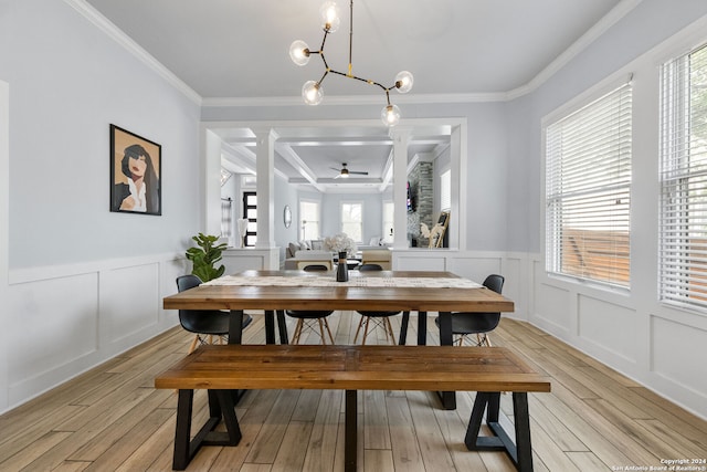 dining area with light wood-type flooring, ceiling fan with notable chandelier, and ornamental molding