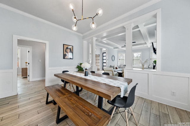 dining area featuring beam ceiling, coffered ceiling, an inviting chandelier, light wood-type flooring, and crown molding