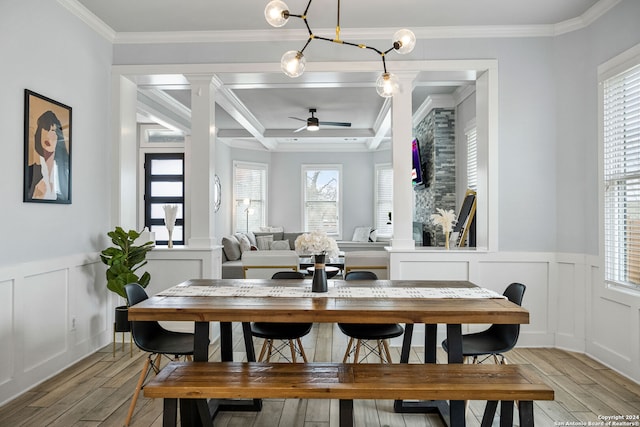 dining space featuring decorative columns, ornamental molding, ceiling fan, and light hardwood / wood-style flooring