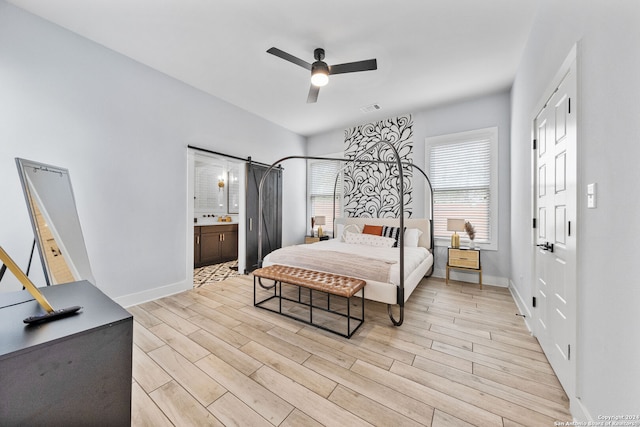 bedroom featuring connected bathroom, light hardwood / wood-style floors, and ceiling fan