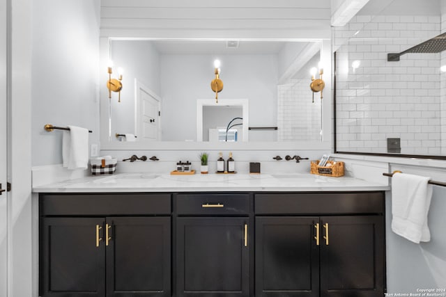 bathroom with tiled shower and vanity