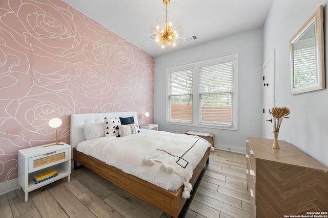 bedroom featuring light hardwood / wood-style flooring, lofted ceiling, and a chandelier