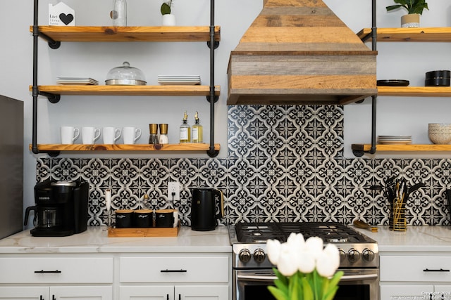 kitchen featuring white cabinets, custom range hood, backsplash, high end stainless steel range, and light stone countertops