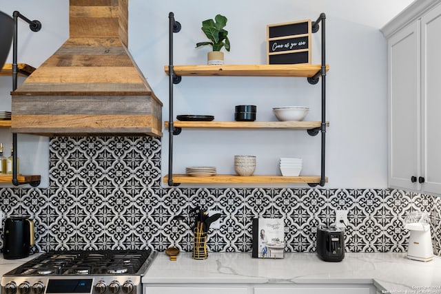 kitchen featuring white cabinetry, stainless steel stove, and tasteful backsplash