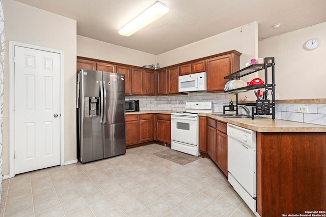 kitchen with tasteful backsplash, appliances with stainless steel finishes, sink, and light tile patterned flooring