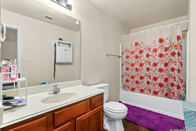 full bathroom featuring shower / bath combo, toilet, wood-type flooring, vanity, and a textured ceiling