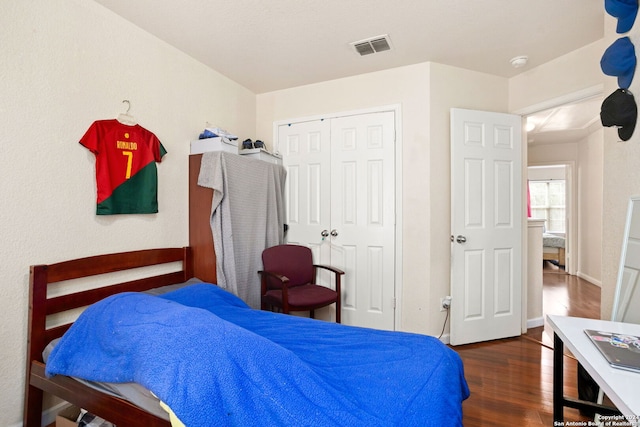 bedroom with a closet and dark hardwood / wood-style flooring