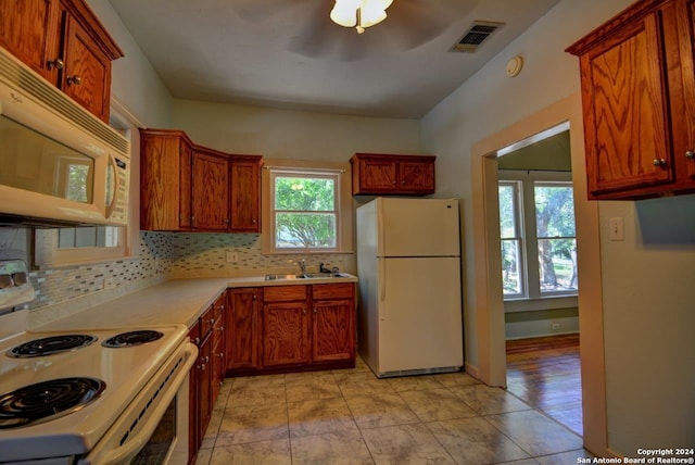 kitchen featuring backsplash, sink, and white appliances