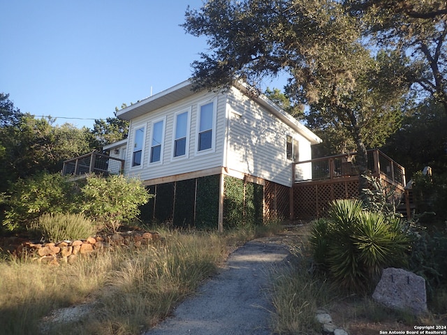 view of side of property featuring a wooden deck