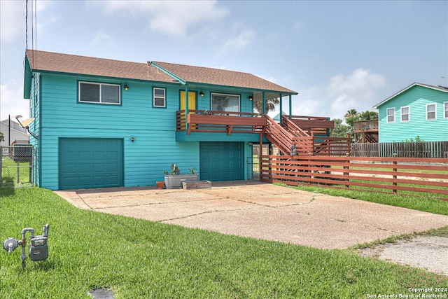 view of front of house with a garage, a wooden deck, and a front yard