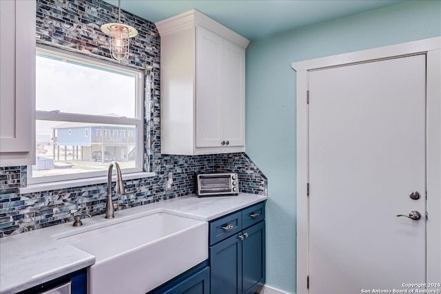 kitchen featuring sink, decorative light fixtures, white cabinetry, blue cabinetry, and decorative backsplash