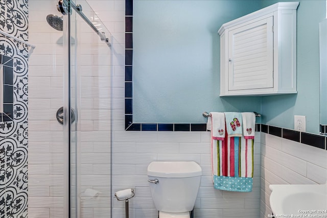 bathroom with tile walls, toilet, and an enclosed shower