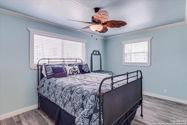 bedroom featuring ceiling fan, hardwood / wood-style flooring, crown molding, and multiple windows