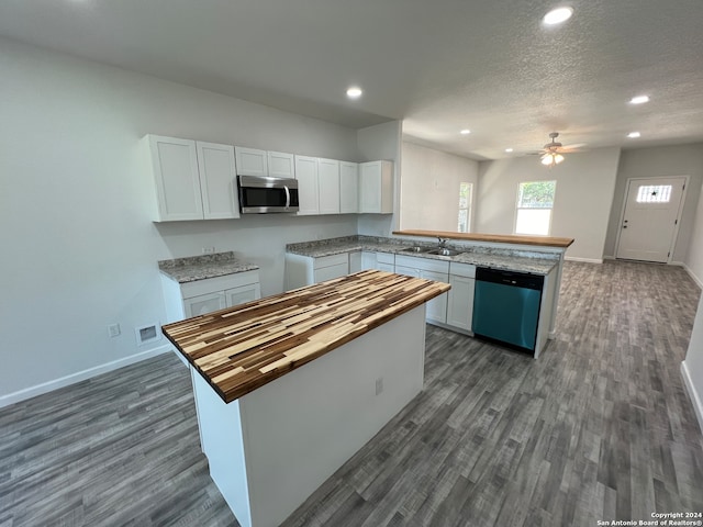 kitchen featuring sink, white cabinetry, stainless steel appliances, a center island, and butcher block counters