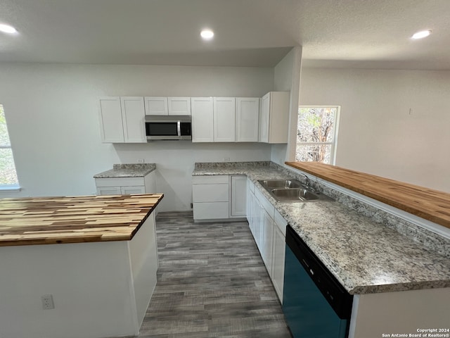 kitchen with white cabinets, dark hardwood / wood-style flooring, wooden counters, stainless steel appliances, and sink